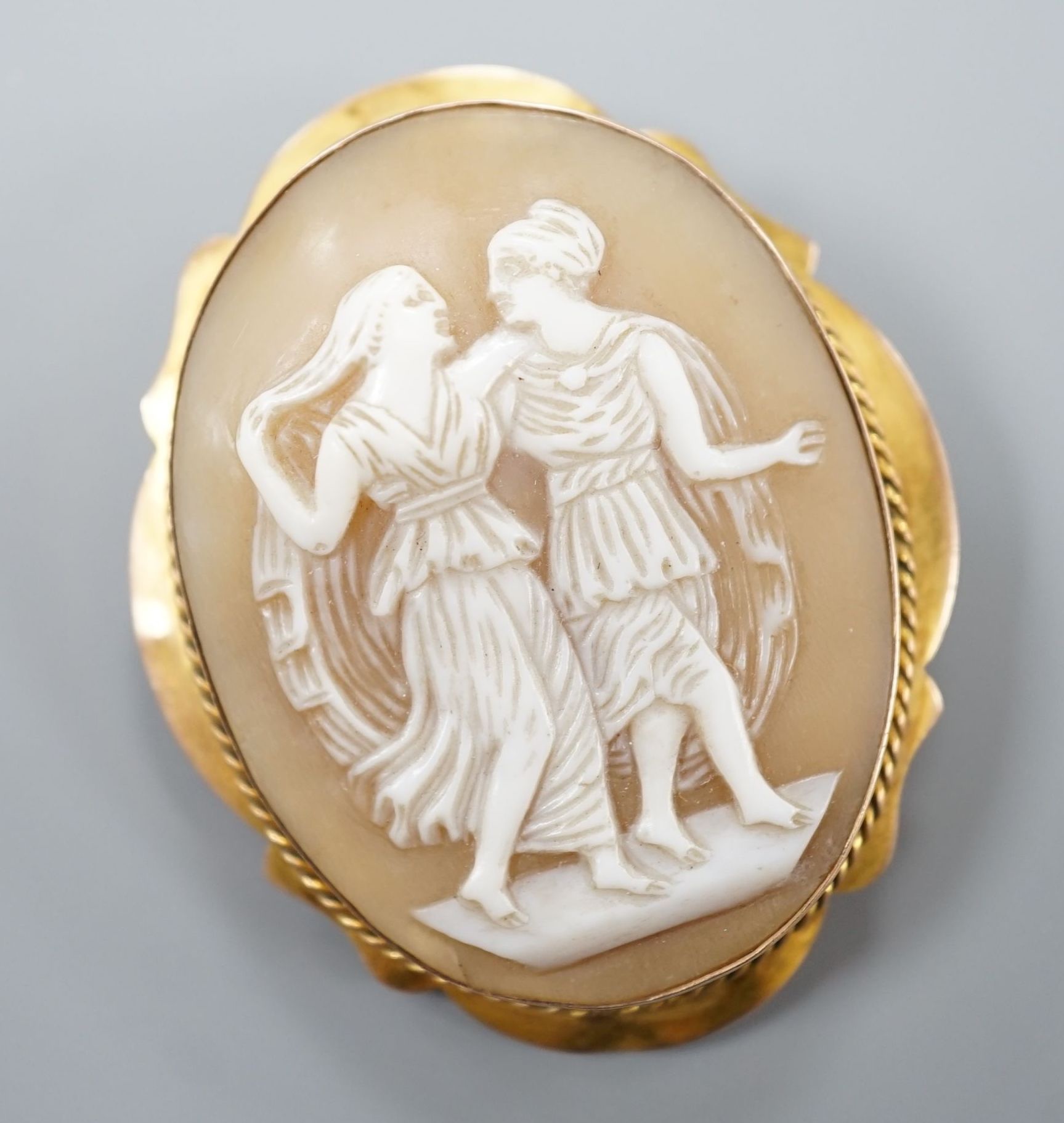 A 9ct mounted oval cameo shell brooch, decorated with two maidens, 46mm, gross 8.9 grams.